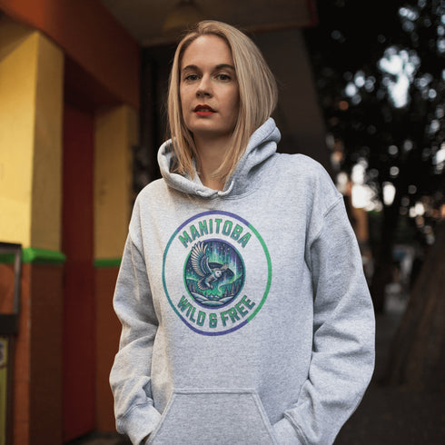 Embrace the magic of the prairies with our Manitoba – Wild & Free hoodie, featuring a captivating graphic of a snowy owl in flight beneath the shimmering northern lights.
